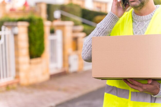 Foto transportista de entrega de paquetes con una caja de una tienda en línea