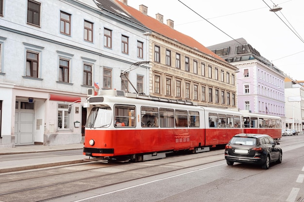 Tranvía rojo típico en la carretera de Mariahilfer Strasse en Innere Stadt en el centro de la ciudad vieja de Viena en Austria. Transporte público y arquitectura de calles en Wien en Europa. Vista del paisaje urbano. Punto de referencia del edificio.