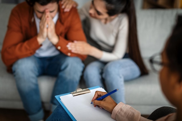 Tratamento de depressão Mulher caucasiana infeliz acalma homem chorando em consulta com psicólogo