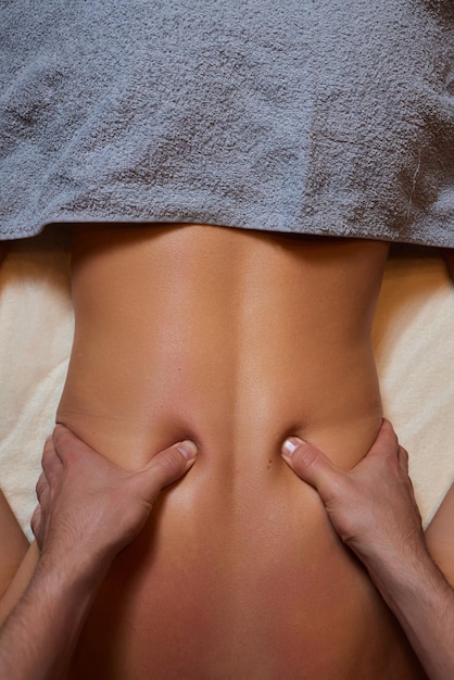Foto tratamento de massagem corporal mulher fazendo massagem no salão de spa massageiro trabalhando nas costas