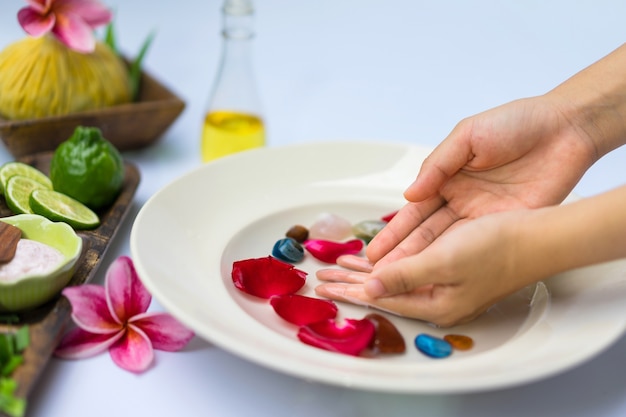 Tratamento de spa e produto para spa de mão com flores e água.