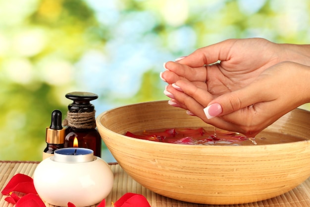 Foto tratamentos de spa para mãos femininas em fundo verde