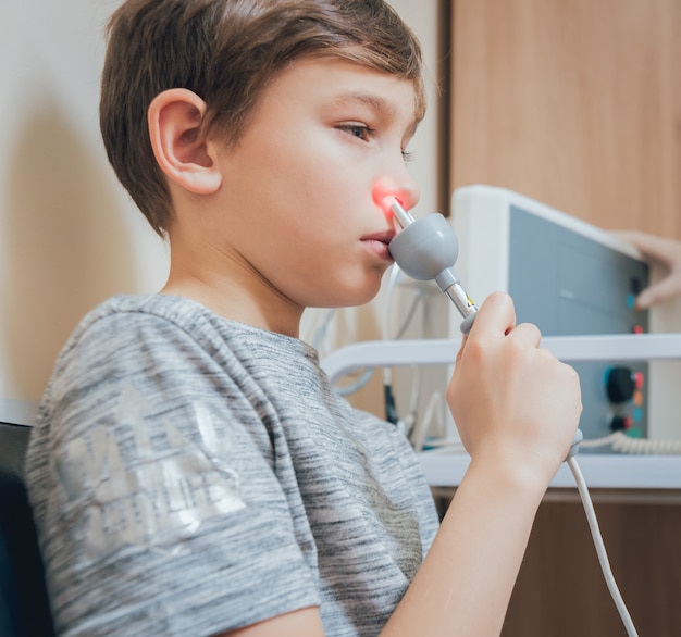 Foto tratamiento y calentamiento de la nariz de un niño. pediatría moderna.