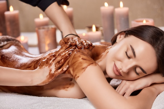 Tratamiento corporal tranquilo y relajante con chocolate en spa con velas