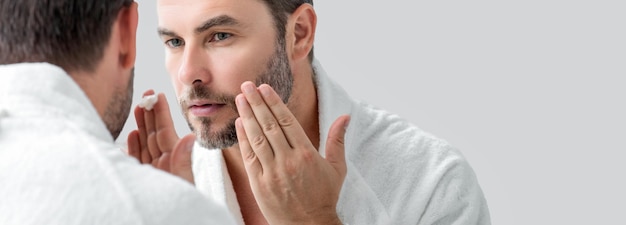 Tratamiento de crema para la rutina de belleza facial masculina cara de un hombre hermoso con piel perfecta antienvejecimiento y