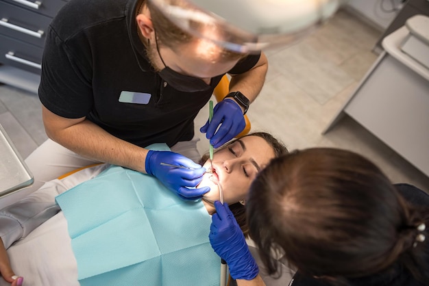 Tratamiento de un diente cariado en la oficina de una clínica dental