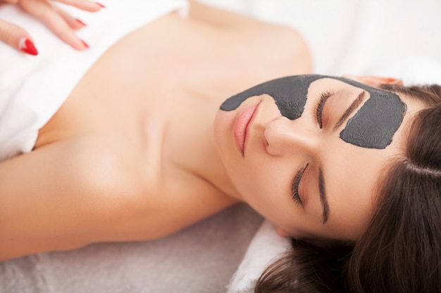 Tratamiento facial. Mujer en salón de belleza obtiene máscara marina