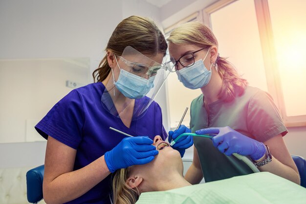 Tratamiento profesional de dientes de pacientes femeninos en el cuidado de la salud de la clínica dental