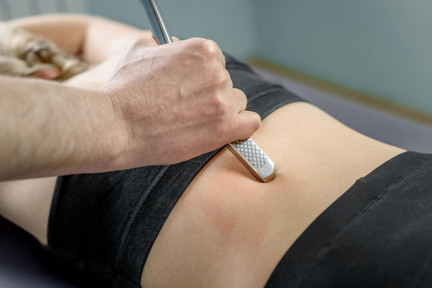 Foto tratamiento quiropráctico con raspado muscular herramienta iastm movilización de tejidos blandos