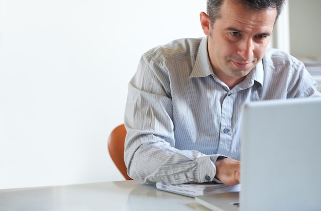 Tratando de cumplir con su fecha límite Captura recortada de un hombre de negocios estresado usando una computadora portátil