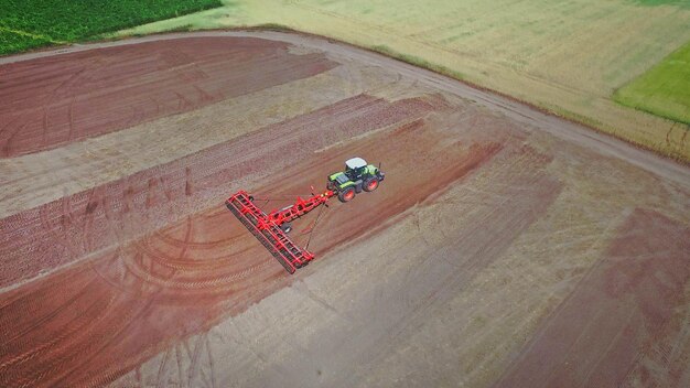 Trator agrícola com reboque arando em campo arado Agricultura rural