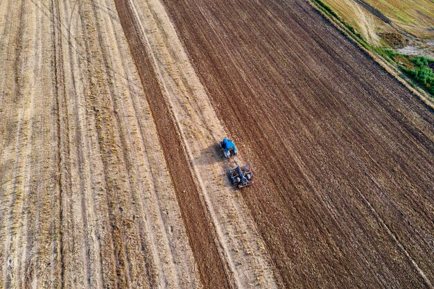 Trator ara terreno em campo cultivado