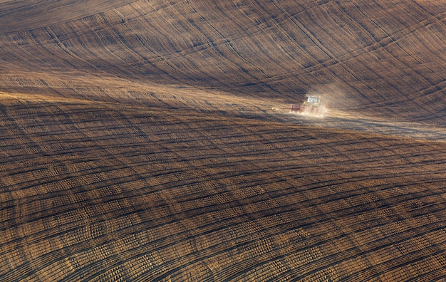 Trator arando um campo despojado