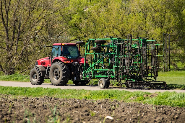 Trator com cultivador na estrada rural