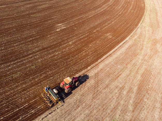 trator com semeadora no campo