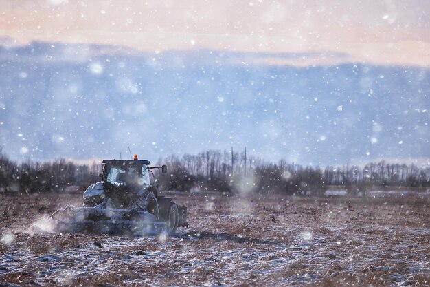 trator no campo terra arável inverno agronegócio paisagem trabalho sazonal em um campo nevado