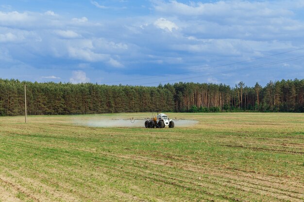 Trator pulveriza fertilizantes químicos líquidos em plantações de milho