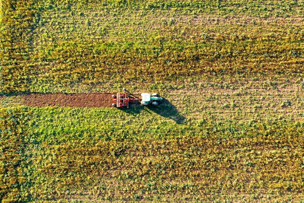 Trator segando campo verde, vista aérea. Agricultura