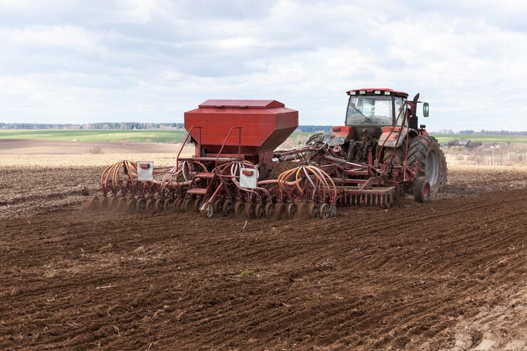 Trator velho produzindo trigo na primavera.