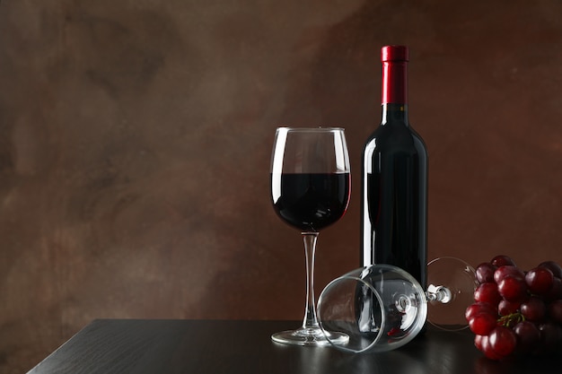 Trauben, Flasche und Glas mit Wein gegen Braun