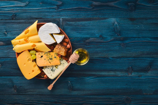 Trauben Rotwein Käse Honig und Nüsse auf einem hölzernen Hintergrund Draufsicht