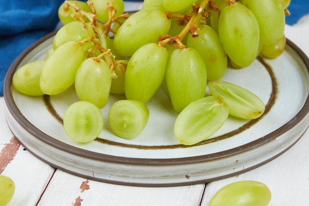 Trauben von frischen reifen grünen Trauben auf einem Holztisch