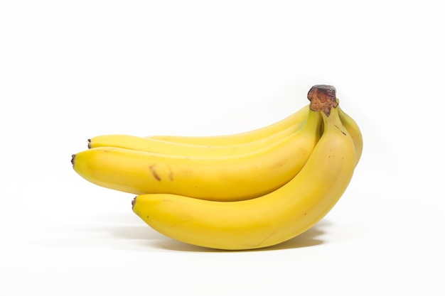 Trauben von gelben Bananen liegen auf einem weißen Hintergrund isoliert