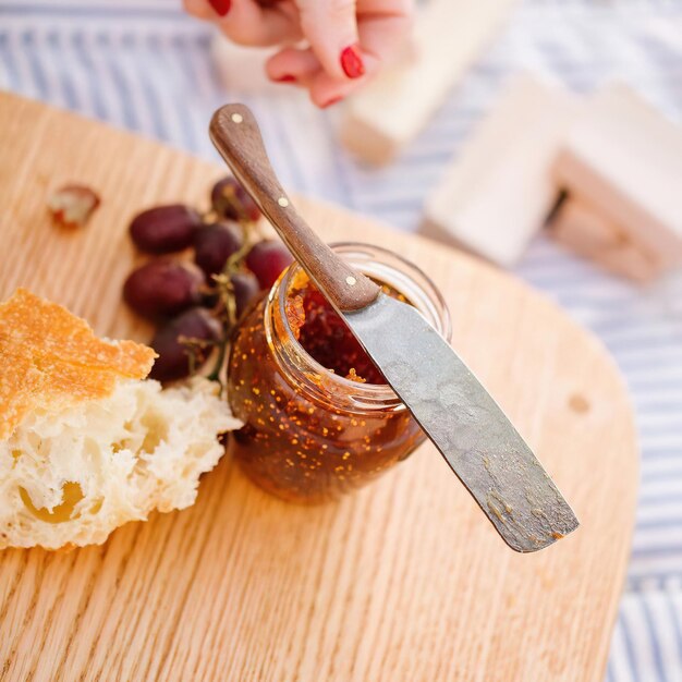 Traubenmarmelade im Glas und Weißbrot auf dem Küchentisch