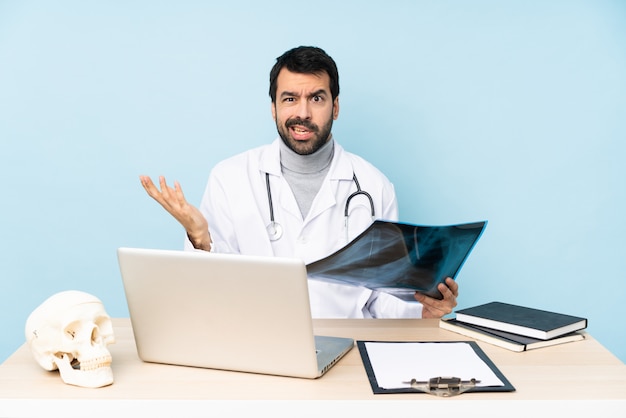 Traumatologista profissional no local de trabalho, fazendo o gesto de dúvidas