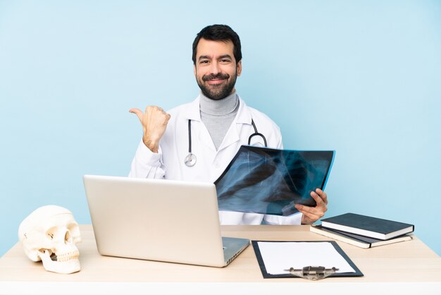 Traumatólogo profesional en el lugar de trabajo apuntando hacia un lado para presentar un producto.