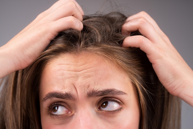 Traurige frau, die geschädigtes haar betrachtet, das haarausfallproblem. studio lokalisiertes porträt, kopienraum.