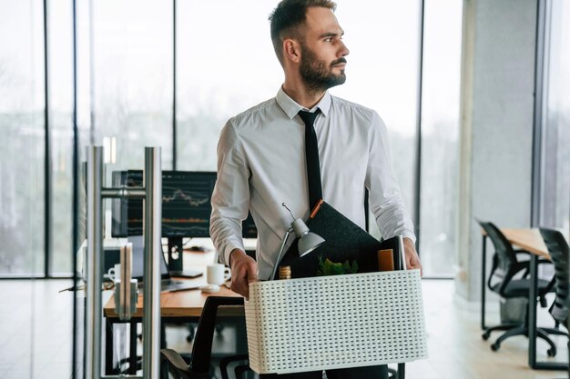 Traurige Person Arbeitsloser Mann ist mit persönlichen Gegenständen nach der Entlassung