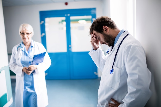 Trauriger Doktor an die Wand gelehnt