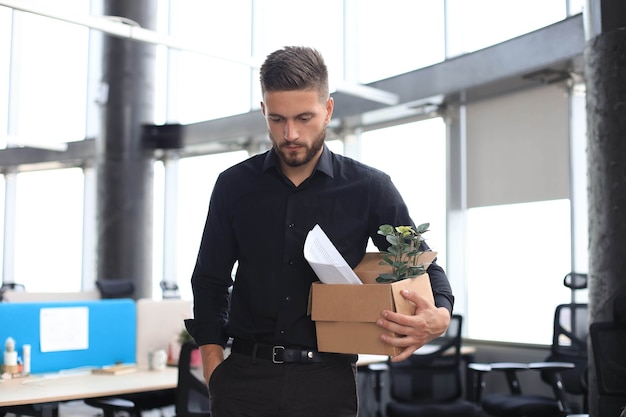 Trauriger entlassener Arbeiter nimmt seine Büromaterialien aus dem Büro mit.