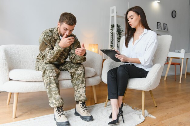 Trauriger männlicher Soldat bei einem Termin beim Psychologen im Büro