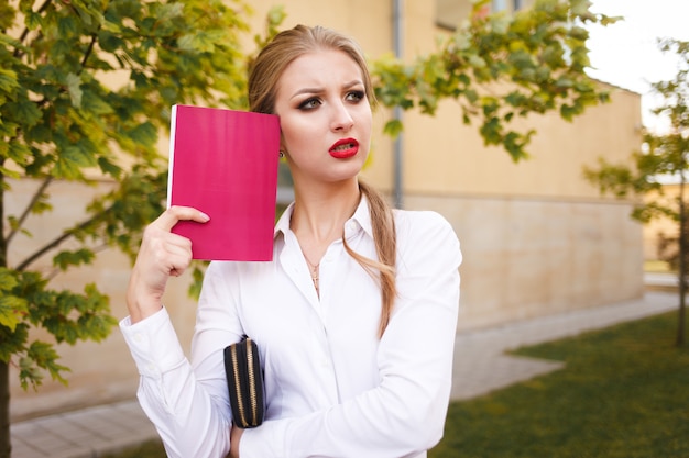 Trauriger Student mit einem Buch in den Händen denkt an Prüfungen. Junge Geschäftsdame denken an Problem auf Arbeit