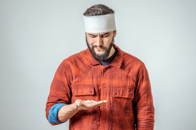 Foto trauriger verletzter verbundener mann mit pillen