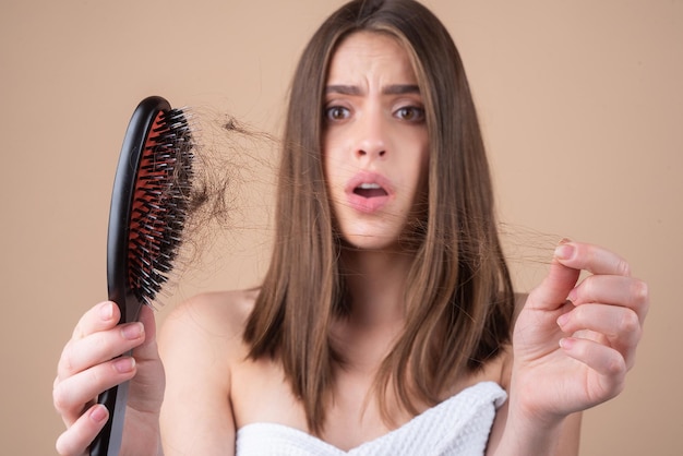 Trauriges Mädchen, das geschädigtes Haar betrachtet, das Haarausfallproblem isolierter Kopienraum