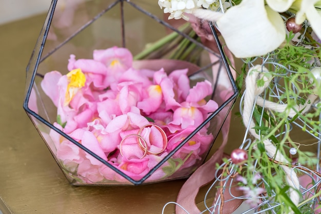 Trauringe in der Boutonniere mit Rosenblättern