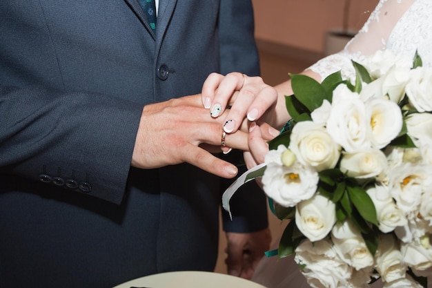 Trauringe und Hände des jungen Hochzeitspaares der Braut und des Bräutigams