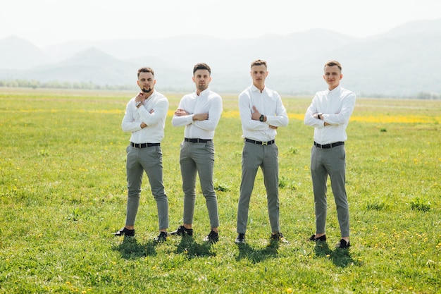 Trauzeugen und Bräutigam posieren am Hochzeitstag im Freien.