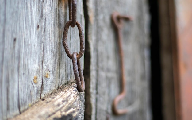 Trava de porta enferrujada velha isolada em uma porta de madeira Closeup Painéis resistidos problemáticos Fundo de textura de parede antigo Detalhe de uma porta de madeira velha com uma trava de porta enferrujada