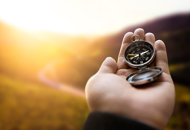 Traveler Explorer Mann hält Kompass in einer Hand in den Bergen bei Sonnenaufgang