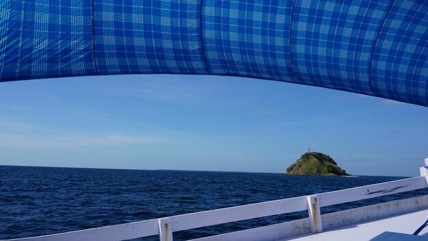 A través de la ventana se ve un bote con una lona azul.