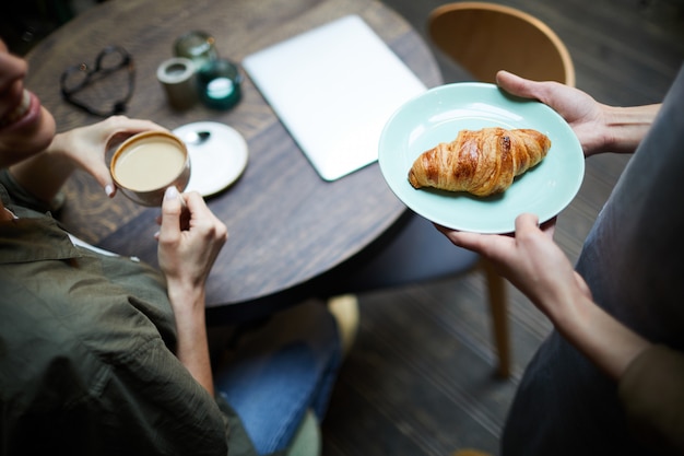 Trazendo croissant crocante ao cliente