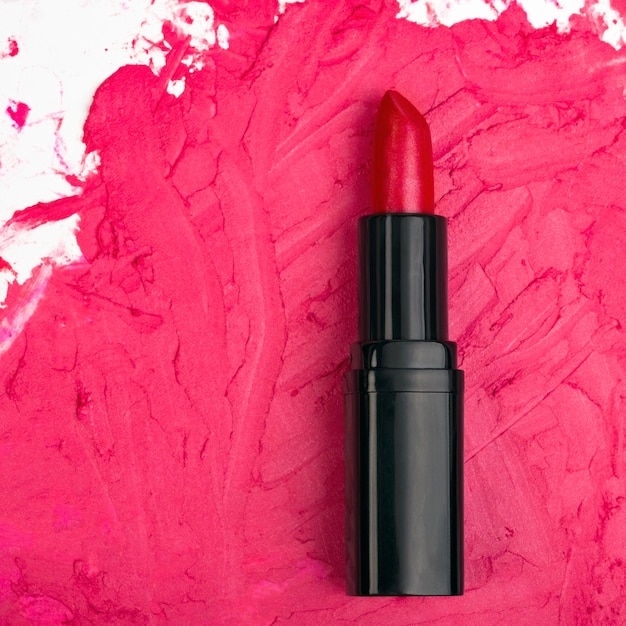 Trazo de lápiz labial rojo en un espacio de maquillaje rojo