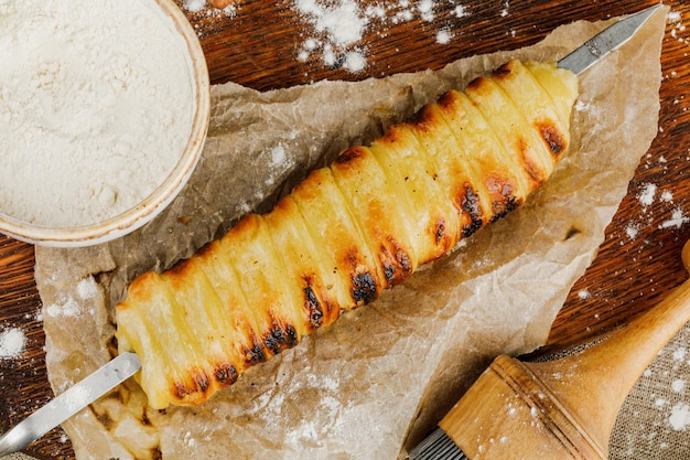 Trdelnik caseiro com utensílios de cozinha na bandeja de madeira