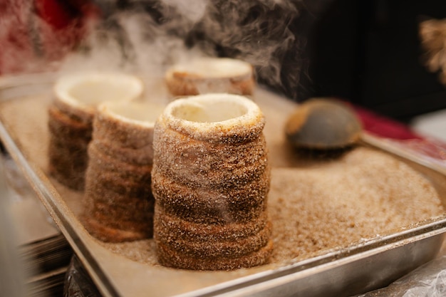 Foto trdelnik oder schornsteinkuchen, der in osteuropa auf der straße gebacken wird