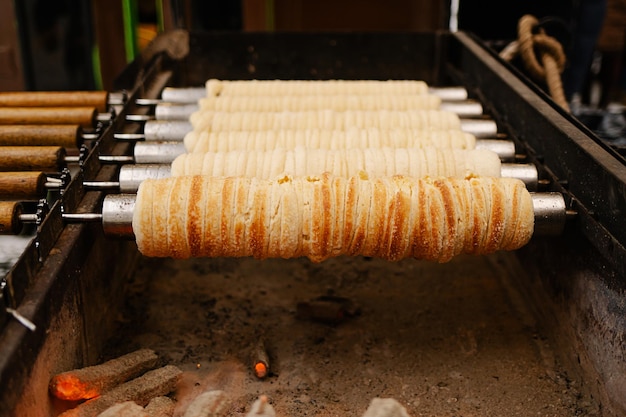 Foto trdelnik oder schornsteinkuchen, der in osteuropa auf der straße gebacken wird