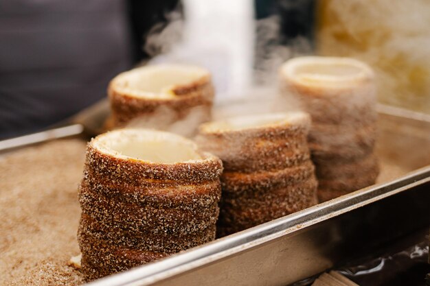 Foto trdelnik oder schornsteinkuchen, der in osteuropa auf der straße gebacken wird